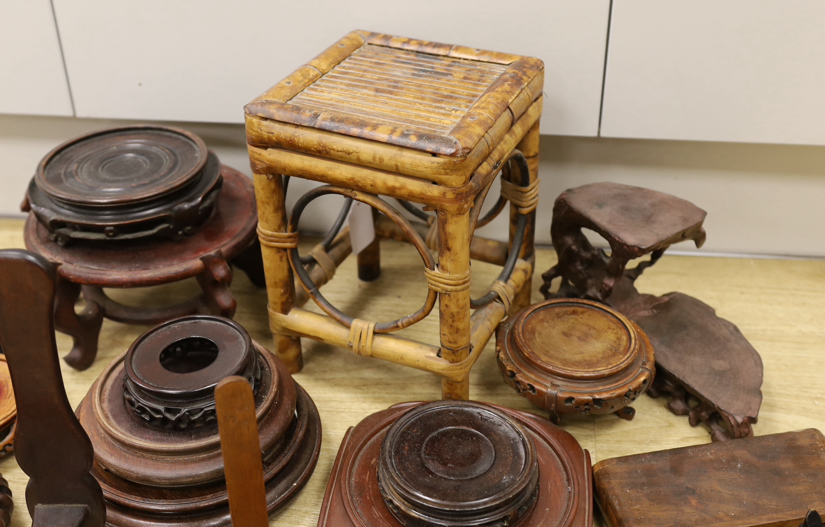 A collection of Chinese carved wooden stands and a small bamboo stand